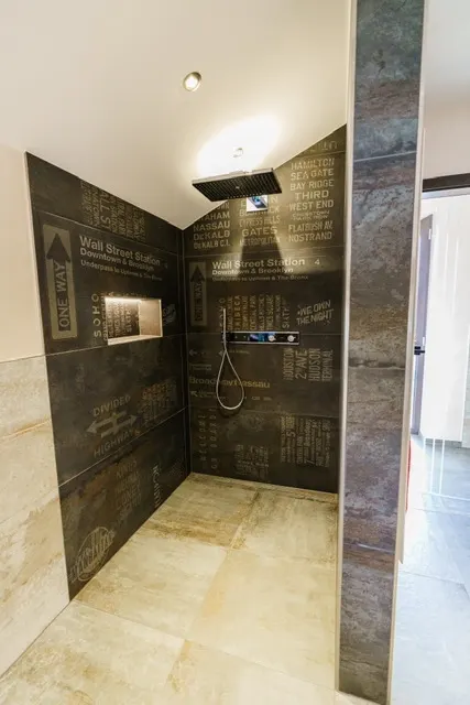 Moderne barrierefreie Badsanierung mit urbanen Designer-Fliesen und Regendusche