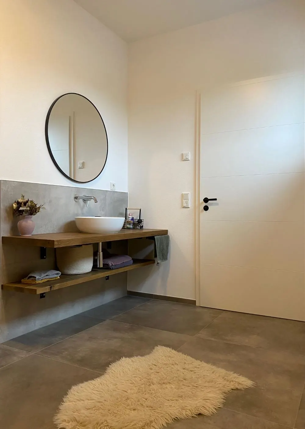 Moderne Badsanierung mit Design-Fliesen und stilvollem Waschtisch aus Holz