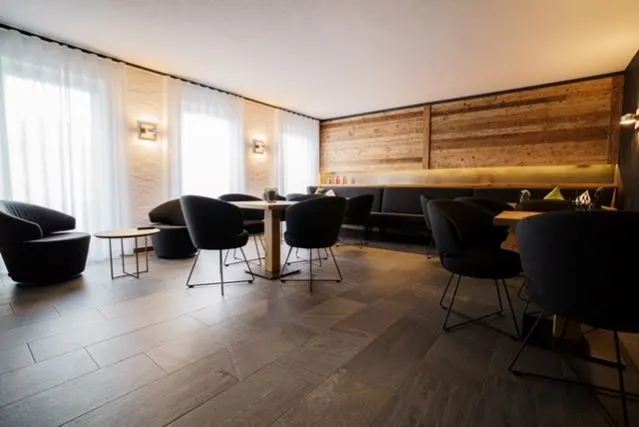 Gemütlicher Loungebereich mit Holzwandverkleidung und großformatigem Bodenbelag