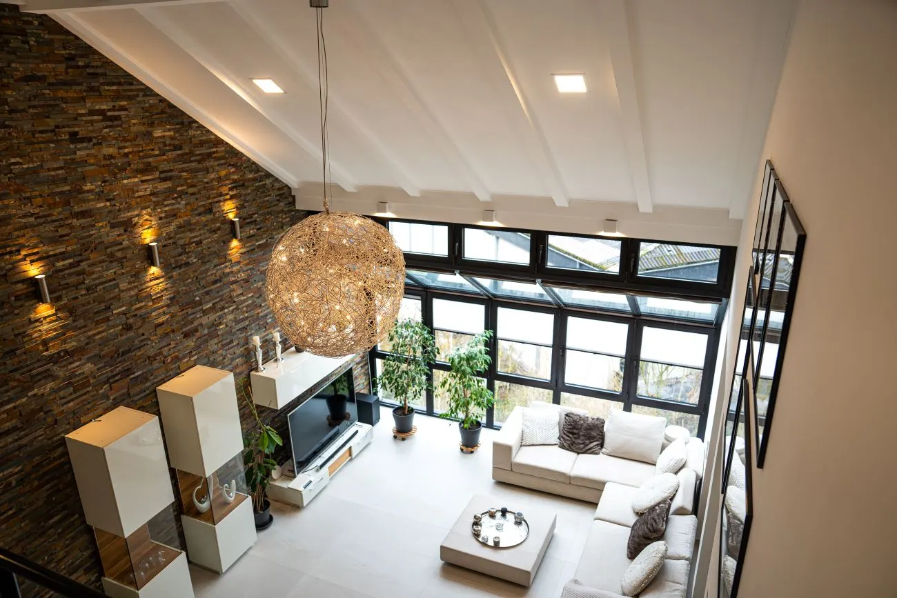 Wohnzimmer mit hoher Decke und großen Fenstern